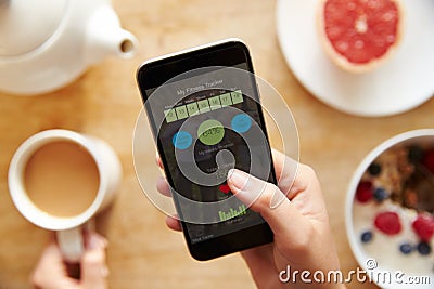 Person At Breakfast Looking At Fitness App On Mobile Phone Stock Photo
