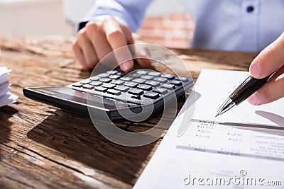 Person Calculating Finance Using Calculator Stock Photo