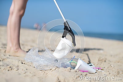 Close Up Of Person Collecting Plastic Waste From Polluted Beach Stock Photo