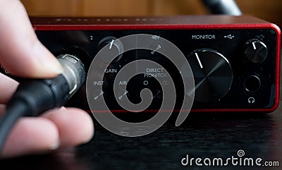 Person connecting a cable to an audio interface Stock Photo