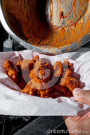 Person cooking some delicious boneless with buffalo sauce Stock Photo