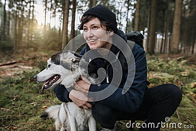 Person hugs his dog in the forest Stock Photo