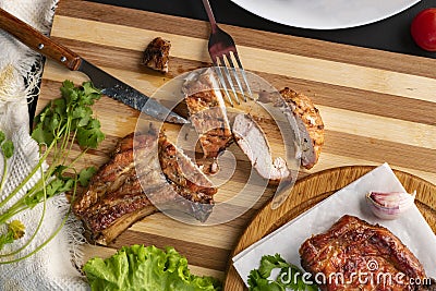 person cutting cooked or grilled beef steak with a knife on a wooden boards Stock Photo