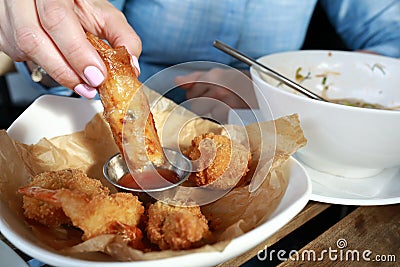 Person dipping Vietnamese Shrimp Spring Roll into sauce Stock Photo