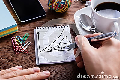 Person Drawing House Prices Growth Concept On Notepad Stock Photo