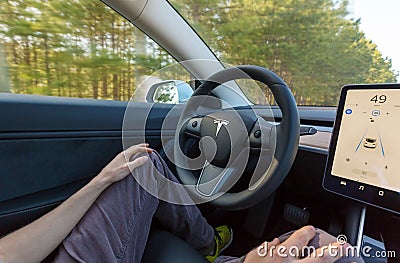 Person driving a new Tesla Model 3 in autopilot mode. Editorial Stock Photo