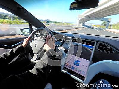 Person driving a Tesla plug-in electric car Model X on a motorway Editorial Stock Photo
