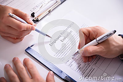 Person Filling Employee Performance Evaluation Form Stock Photo