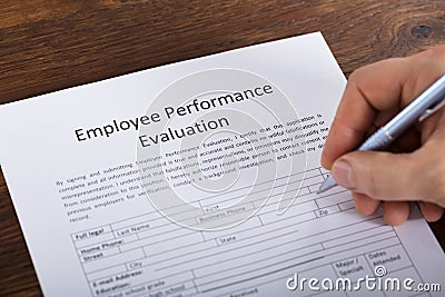 Person Filling A Performance Evaluation Form Stock Photo