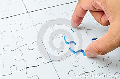 Person fitting the last puzzle piece Stock Photo