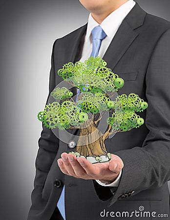 A person in formal suit holds a sketched tree on the palm Stock Photo
