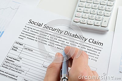 Person hand with pen filling social security disability form Stock Photo