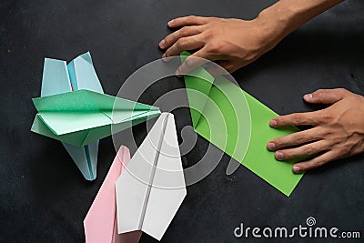person hands making a origami color paper planes Stock Photo