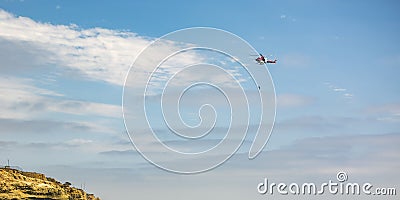 Person hanging on chopper above cliff in La Jolla Stock Photo