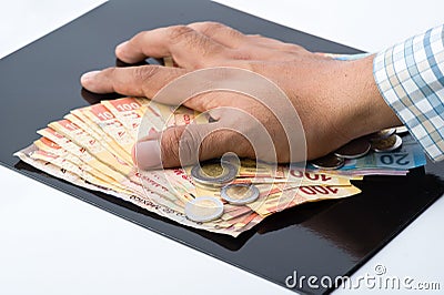 A person hoarding all the money and documents for their own benefit Stock Photo