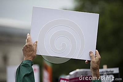 A person holding a blank protest banner at a political rally Stock Photo