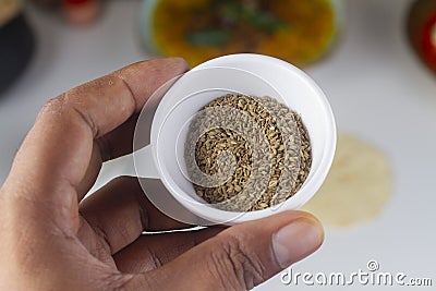 A person holding a celery seed bowl in hand on light background Stock Photo