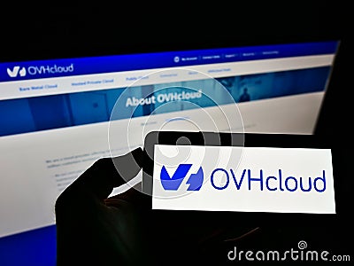Person holding cellphone with business logo of French cloud computing company OVH Groupe SAS on screen in front of web page. Editorial Stock Photo