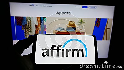 Person holding cellphone with logo of US financial technology company Affirm Holdings Inc. on screen in front of web page. Editorial Stock Photo