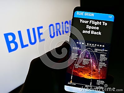 Person holding cellphone with web page of US aerospace company Blue Origin LLC on screen in front of business logo. Editorial Stock Photo