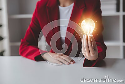 Person holding glowing lamp, Creative new idea. Innovation, brainstorming, strategizing to make the business grow and be Stock Photo