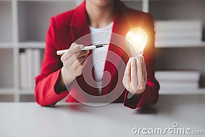 Person holding glowing lamp, Creative new idea. Innovation, brainstorming, strategizing to make the business grow and be Stock Photo