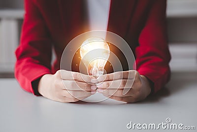 Person holding glowing lamp, Creative new idea. Innovation, brainstorming, strategizing to make the business grow and be Stock Photo