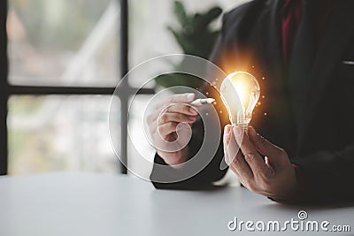 Person holding glowing lamp, Creative new idea. Innovation, brainstorming, strategizing to make the business grow and be Stock Photo