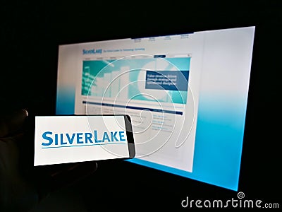 Person holding mobile phone with logo of US private equity investment company Silver Lake Technology Management on display. Editorial Stock Photo