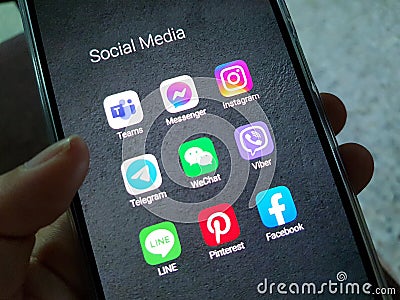 A person holding a mobile phone with screen showing social media applications Editorial Stock Photo