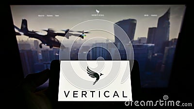 Person holding smartphone with logo of British aircraft company Vertical Aerospace Ltd. on screen in front of website. Editorial Stock Photo
