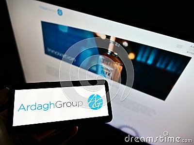 Person holding smartphone with logo of Luxembourgish packaging company Ardagh Group S.A. on screen in front of website. Editorial Stock Photo