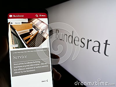 Person holding smartphone with web page of German legislative body Bundesrat on screen in front of seal. Editorial Stock Photo