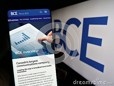 Person holding smartphone with webpage of Canadian telecommunications company BCE Inc. on screen with logo. Editorial Stock Photo