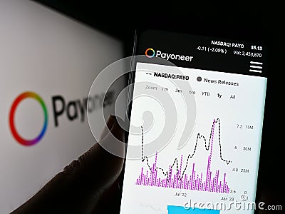 Person holding smartphone with webpage of payments company Payoneer Global Inc. on screen in front of logo. Editorial Stock Photo