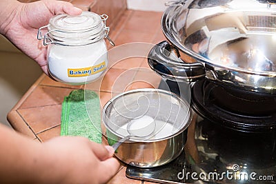 Person holding spoonful mixed baking soda, effective natural cleaning agent Stock Photo