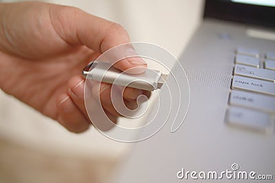 Person inserting plug in flashdisk into usb port in laptop personal computer, data transfer device concept Stock Photo