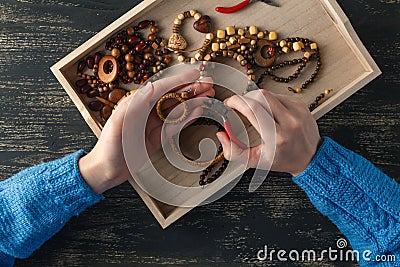 Person making jewelry using wire, chains and beads and other materials with craft tools Stock Photo
