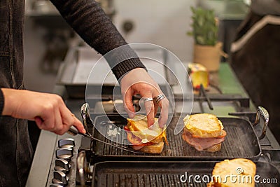 Person making toasts on a pan in a kitchen Stock Photo