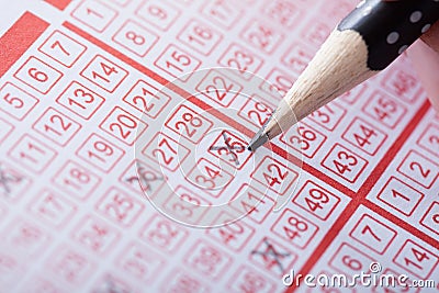 Person marking number on lottery ticket Stock Photo