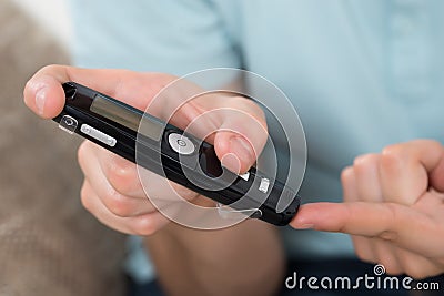 Person Measuring Blood Sugar With Glucometer Stock Photo