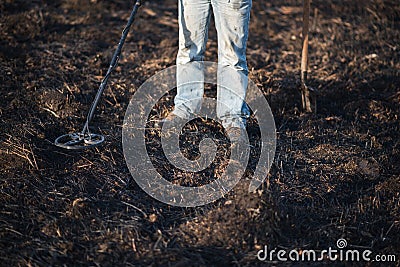 A person with a metal detector in a field, search for coins, hobbies Stock Photo