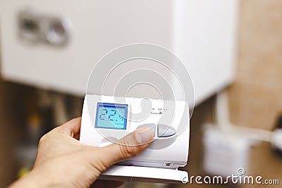 Person near central heating controlling the temperature with a r Stock Photo