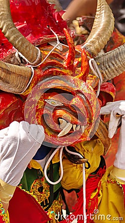 Person in an orange devil mask at the Diablada Editorial Stock Photo