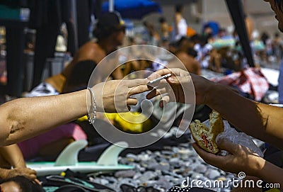 Person paying for a sandwich at the beach of Makaha in Lima Peru. Editorial Stock Photo