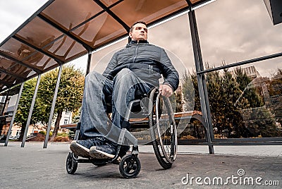 Person with a physical disability waiting for city transport with an accessible ramp. Stock Photo