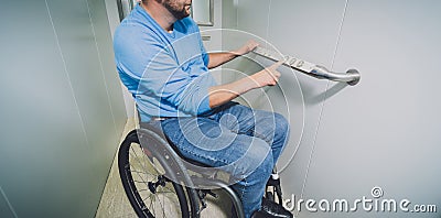 Person with a physical disability in a wheelchair using lift in building Stock Photo