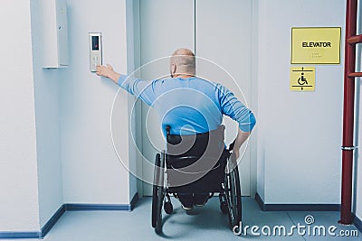 Person with a physical disability in a wheelchair using lift in building Stock Photo