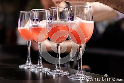 Person pouring glasses of red wine for everyone to enjoy Stock Photo