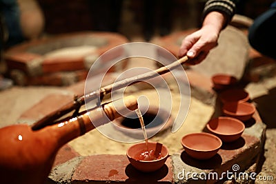 Person pouring wine from qvevri using Orshimo Stock Photo